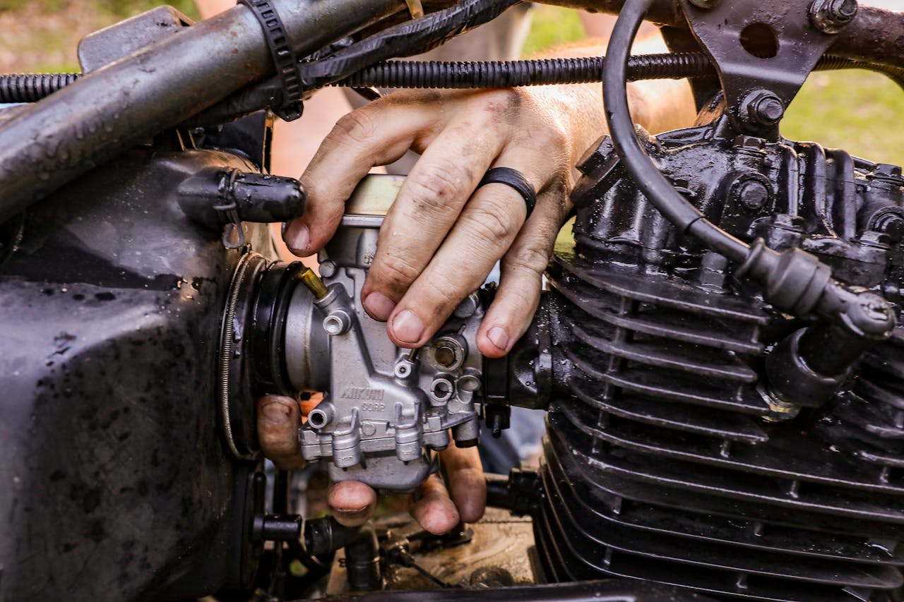 Close-up of hands fixing a motorcycle engine with tools in Orlando.