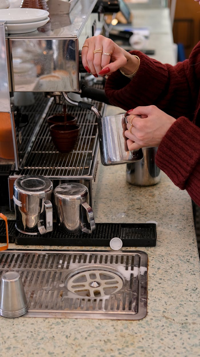 A skilled barista prepares coffee at a café in İstanbul, Türkiye, showcasing espresso brewing technique.